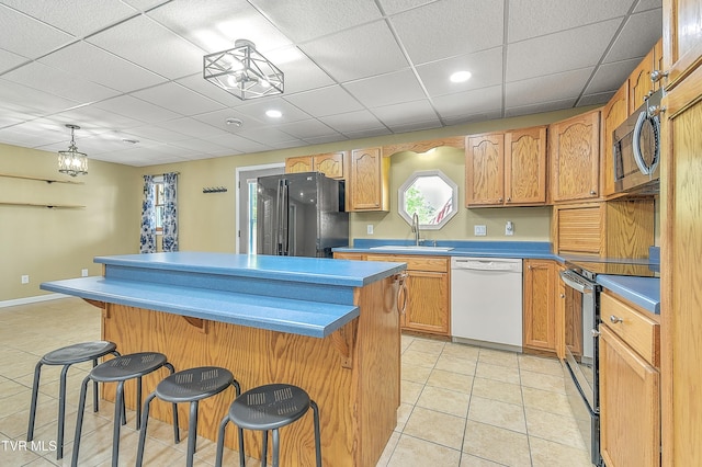 476 Sportsman Dock Rd, Piney Flats, TN 37686 - kitchen with stainless steel appliances, a sink, a kitchen island, light tile patterned flooring, and a kitchen bar