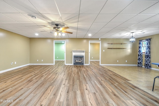 476 Sportsman Dock Rd, Piney Flats, TN 37686 - unfurnished living room featuring a paneled ceiling, a fireplace, light wood-style flooring, baseboards, and a ceiling fan