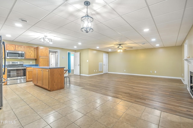 476 Sportsman Dock Rd, Piney Flats, TN 37686 - kitchen featuring appliances with stainless steel finishes, light wood-style flooring, open floor plan, baseboards, and a kitchen bar