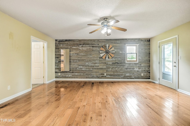 476 Sportsman Dock Rd, Piney Flats, TN 37686 - empty room with an accent wall, ceiling fan, wood finished floors, baseboards, and a textured ceiling