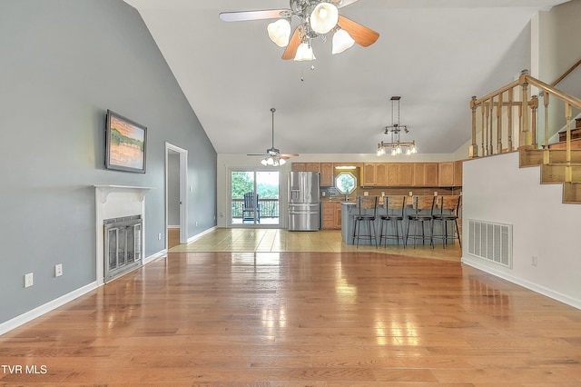 476 Sportsman Dock Rd, Piney Flats, TN 37686 - unfurnished living room with ceiling fan, high vaulted ceiling, light wood finished floors, baseboards, and a fireplace