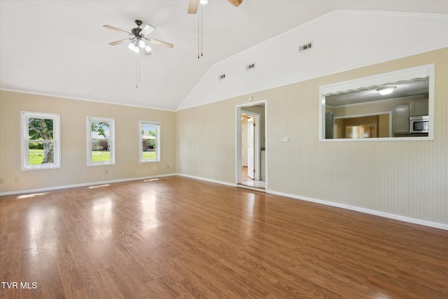 1700 Ridgeway Dr, Kingsport, TN 37664 - unfurnished living room featuring lofted ceiling, healthy amount of natural light, ceiling fan, wood finished floors, and baseboards