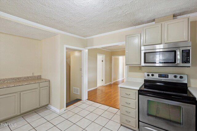 1700 Ridgeway Dr, Kingsport, TN 37664 - kitchen with stainless steel appliances, light countertops, light tile patterned floors, a textured ceiling, and crown molding