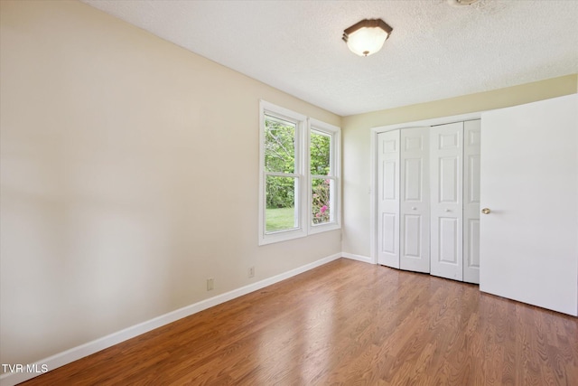 1700 Ridgeway Dr, Kingsport, TN 37664 - unfurnished bedroom featuring wood finished floors, baseboards, a closet, and a textured ceiling