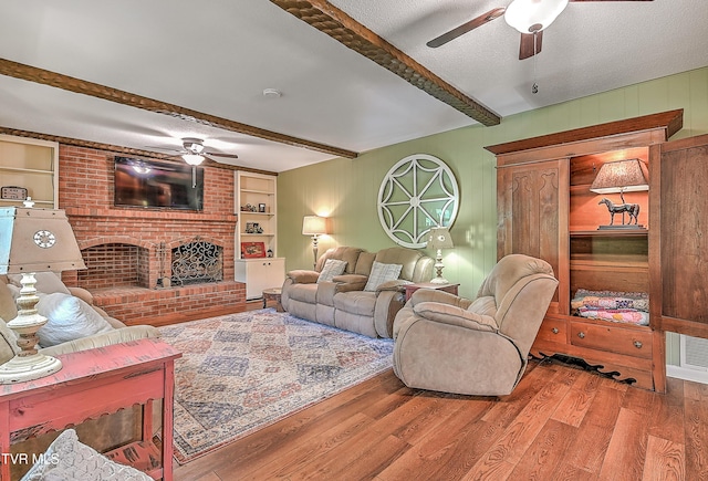 2309 Oxford Ct, Kingsport, TN 37660 - living room featuring a ceiling fan, beam ceiling, wood finished floors, a brick fireplace, and wood walls