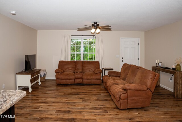 living area with wood finished floors, a ceiling fan, and baseboards