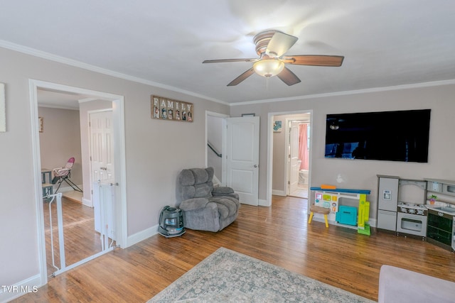 176 N Main St, Oneida, TN 37841 - living area featuring a ceiling fan, wood finished floors, crown molding, baseboards, and stairs
