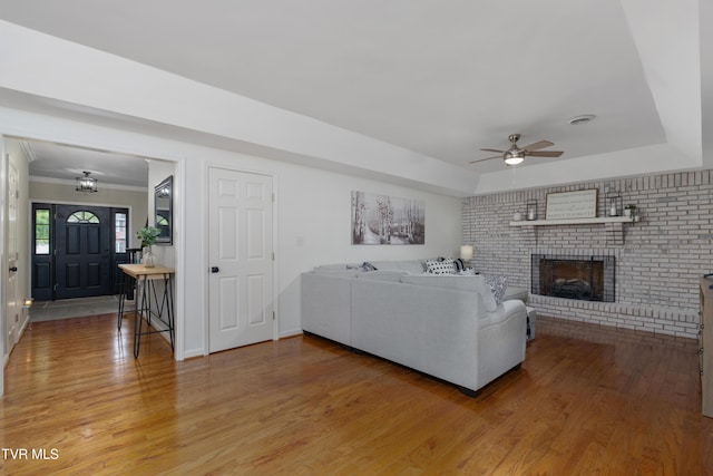 821 Regency Dr, Johnson City, TN 37604 - living room with light wood-style floors, a ceiling fan, a fireplace, ornamental molding, and a tray ceiling