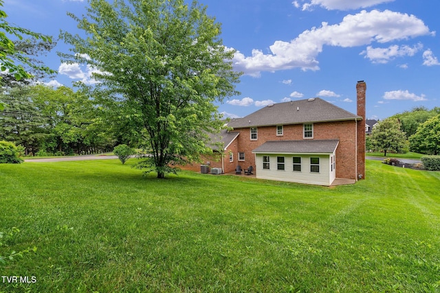 821 Regency Dr, Johnson City, TN 37604 - rear view of house with a yard, a chimney, and brick siding