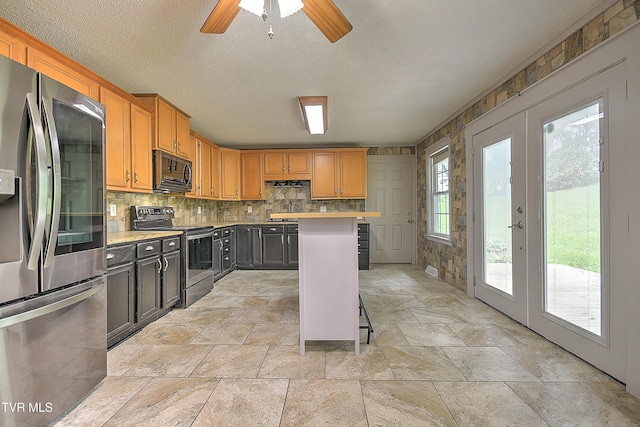 18505 Ironwood Loop, Abingdon, VA 24210 - kitchen featuring stainless steel appliances, light countertops, stone tile floors, a textured ceiling, and tasteful backsplash