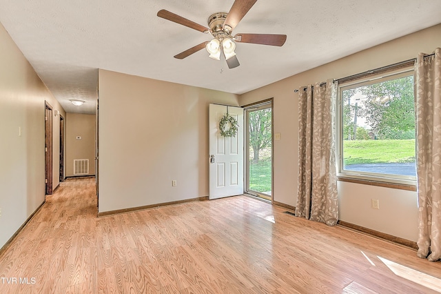 unfurnished room with light wood finished floors, ceiling fan, and baseboards