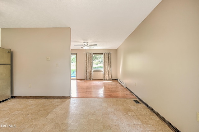 spare room featuring a ceiling fan, baseboards, and a baseboard heating unit