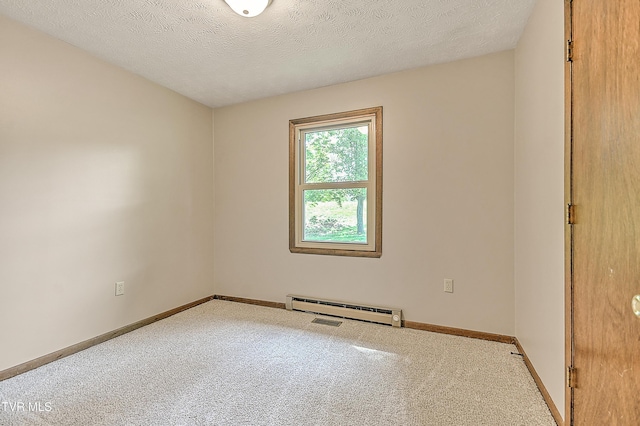 empty room with a baseboard heating unit, carpet, baseboards, and a textured ceiling