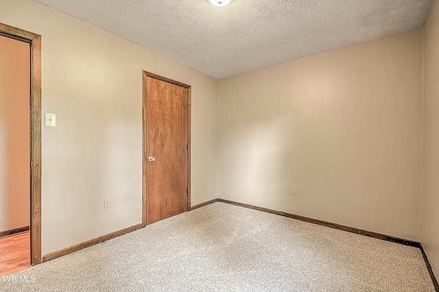 empty room featuring baseboards and a textured ceiling
