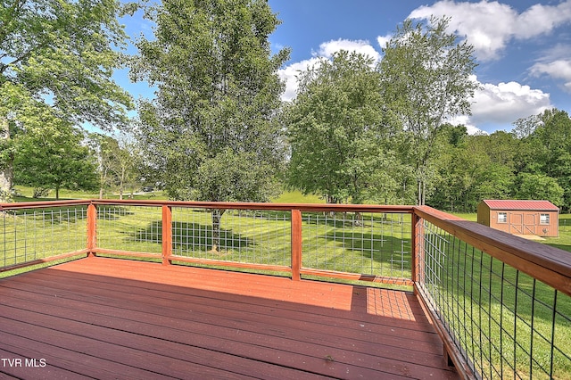 deck featuring a storage shed, a yard, and an outdoor structure