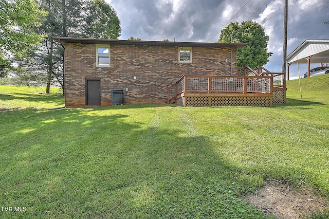 rear view of property with a wooden deck, brick siding, and a yard