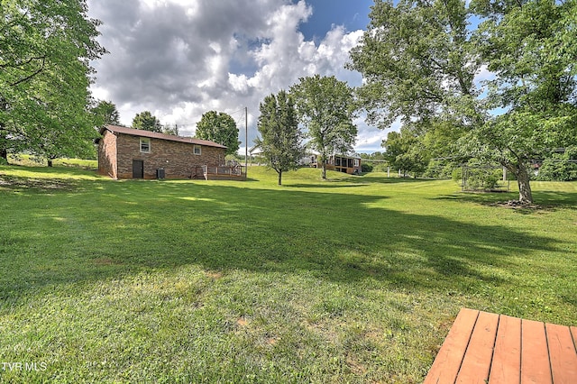 view of grassy yard featuring a wooden deck