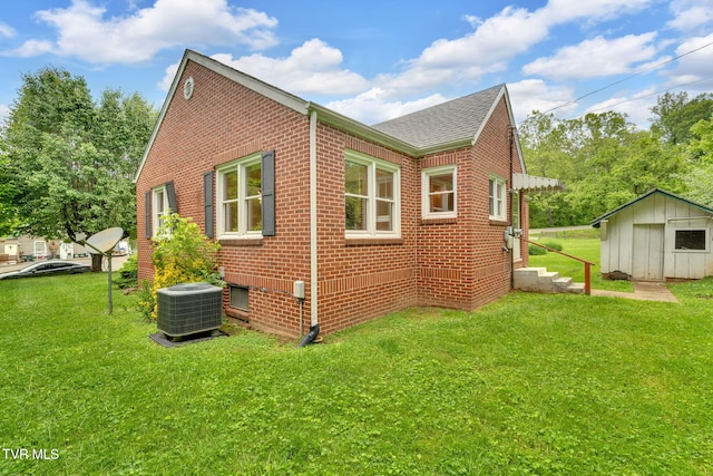8836 Bristol Hwy, Hiltons, VA 24258 - view of side of home with central AC, a shingled roof, brick siding, a lawn, and a storage unit