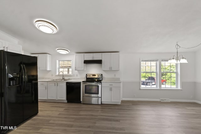 558 Oakland Dr, Bybee, TN 37713 - kitchen with black appliances, a sink, under cabinet range hood, light countertops, and wood finished floors