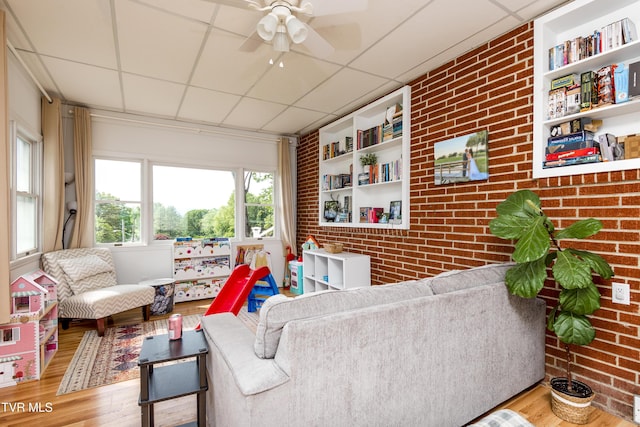 963 NE Woodlawn Ter, Abingdon, VA 24210 - living room with brick wall, a drop ceiling, wood finished floors, and ceiling fan