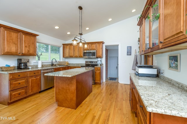 963 NE Woodlawn Ter, Abingdon, VA 24210 - kitchen with appliances with stainless steel finishes, a sink, brown cabinets, vaulted ceiling, and light wood-style flooring