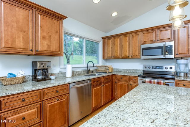 963 NE Woodlawn Ter, Abingdon, VA 24210 - kitchen featuring appliances with stainless steel finishes, a sink, brown cabinetry, vaulted ceiling, and light stone counters