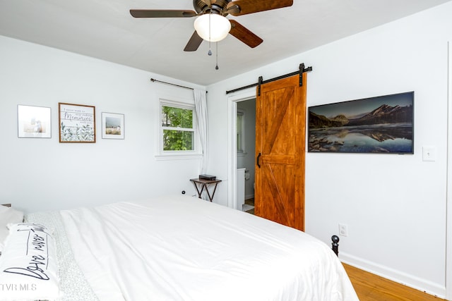 963 NE Woodlawn Ter, Abingdon, VA 24210 - bedroom with wood finished floors, a barn door, a ceiling fan, and baseboards