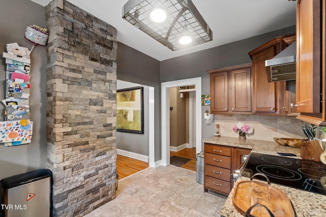408 N Main St, Greeneville, TN 37745 - kitchen featuring wall chimney exhaust hood, brown cabinets, backsplash, and baseboards