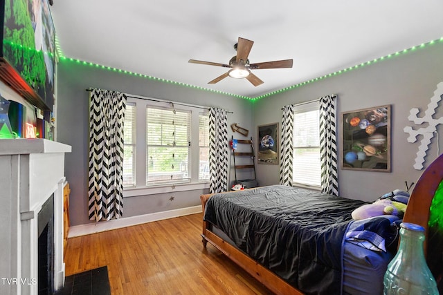 408 N Main St, Greeneville, TN 37745 - bedroom with baseboards, multiple windows, wood finished floors, and a fireplace with flush hearth