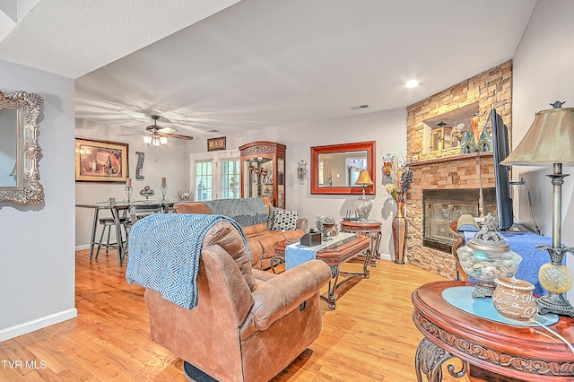 204 E Mountain View Rd # 20, Johnson City, TN 37601 - living area with a stone fireplace, light wood-style floors, a ceiling fan, and baseboards