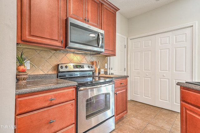 kitchen featuring stainless steel appliances, tasteful backsplash, and light tile patterned flooring