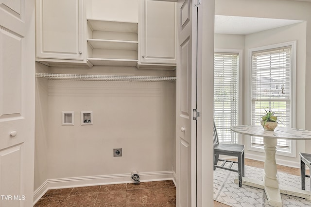 washroom featuring cabinet space, washer hookup, electric dryer hookup, and baseboards