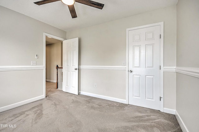 unfurnished bedroom with carpet floors, baseboards, and ceiling fan