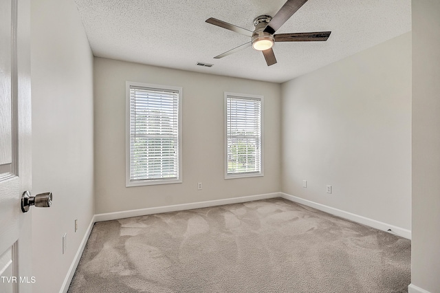 unfurnished room with a ceiling fan, carpet floors, a textured ceiling, and baseboards