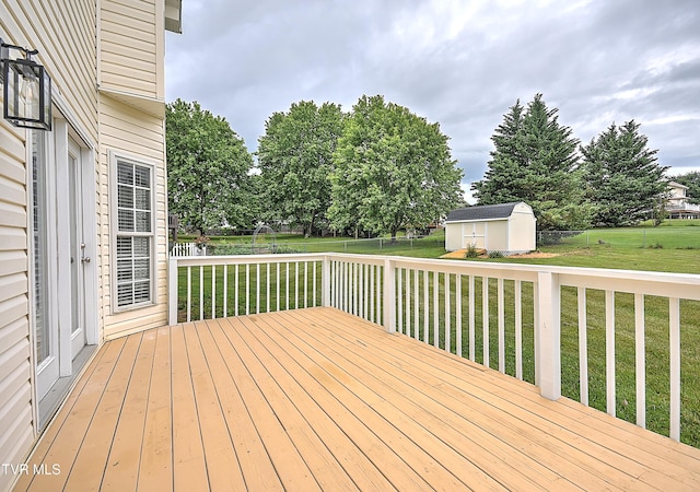 wooden deck with a storage unit and an outbuilding