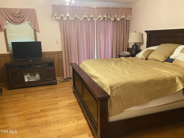203 Oak Ln, Johnson City, TN 37604 - bedroom featuring wainscoting, wood walls, and light wood finished floors