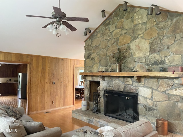 203 Oak Ln, Johnson City, TN 37604 - living room with wood walls, ceiling fan, wood finished floors, a stone fireplace, and high vaulted ceiling