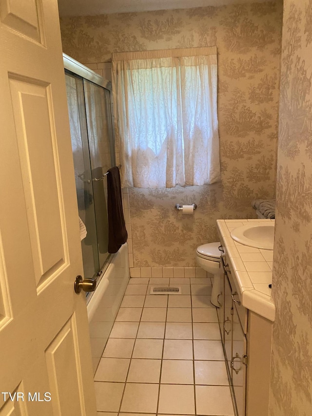 203 Oak Ln, Johnson City, TN 37604 - bathroom featuring tile patterned flooring, vanity, toilet, wallpapered walls, and enclosed tub / shower combo