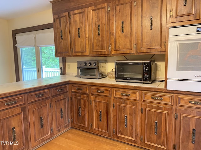 203 Oak Ln, Johnson City, TN 37604 - kitchen with oven, tile counters, and brown cabinetry