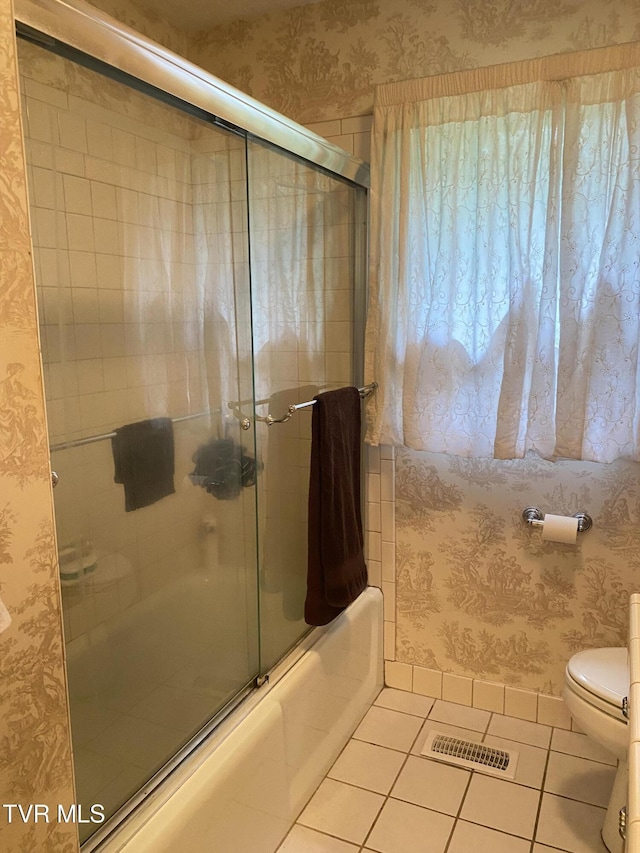 203 Oak Ln, Johnson City, TN 37604 - full bath with tile patterned floors, wallpapered walls, toilet, and shower / bath combination with glass door