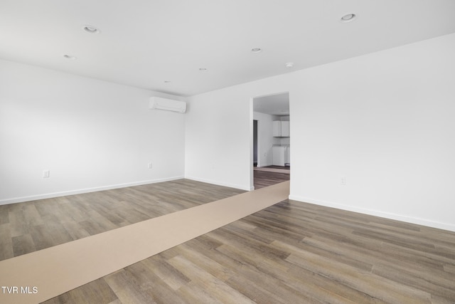 1410 Anderson St, Bristol, TN 37620 - empty room with wood finished floors, baseboards, recessed lighting, and an AC wall unit