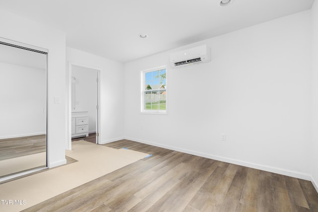 1410 Anderson St, Bristol, TN 37620 - unfurnished bedroom with a wall unit AC, wood finished floors, baseboards, recessed lighting, and a closet
