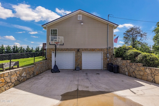 1086 Quaker Run, Telford, TN 37690 - view of property exterior with fence, stone siding, an attached garage, and driveway