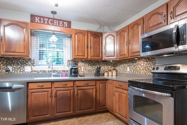 3493 Weaver Pike, Bristol, TN 37620 - kitchen featuring appliances with stainless steel finishes, a sink, a textured ceiling, brown cabinetry, and backsplash