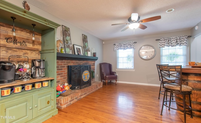3493 Weaver Pike, Bristol, TN 37620 - dining room featuring ceiling fan, a fireplace, light wood finished floors, baseboards, and a textured ceiling