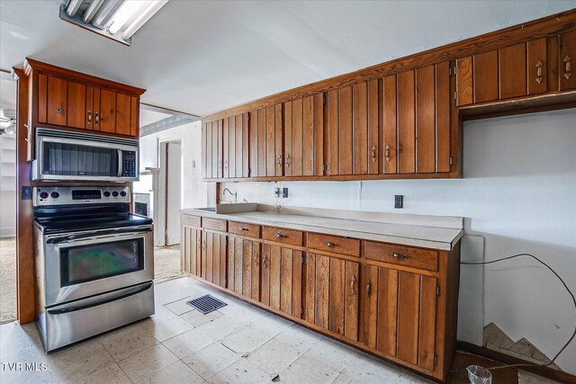 454 Cedar St, Bluff City, TN 37618 - kitchen featuring appliances with stainless steel finishes, light countertops, brown cabinets, and light flooring