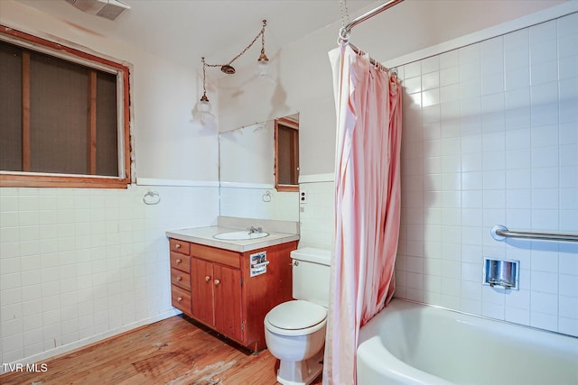 454 Cedar St, Bluff City, TN 37618 - full bathroom with tile walls, wood finished floors, vanity, shower / tub combo, and a wainscoted wall