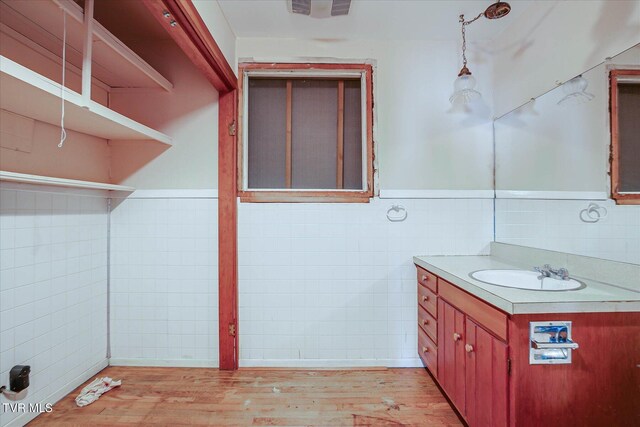 454 Cedar St, Bluff City, TN 37618 - bathroom featuring tile walls, wood finished floors, vanity, and a wainscoted wall