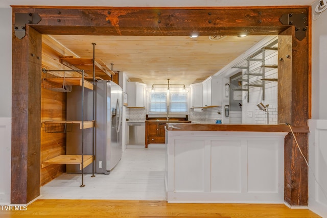 kitchen featuring appliances with stainless steel finishes, a peninsula, light wood-style floors, white cabinetry, and wood ceiling