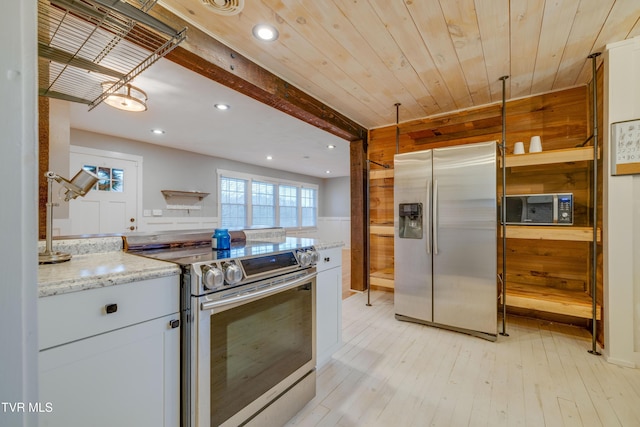 kitchen with stainless steel appliances, white cabinets, recessed lighting, light wood-type flooring, and light stone counters